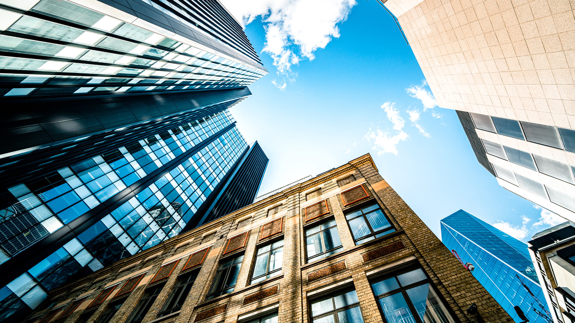 Low angle shot of an old building surrounded by new buildings