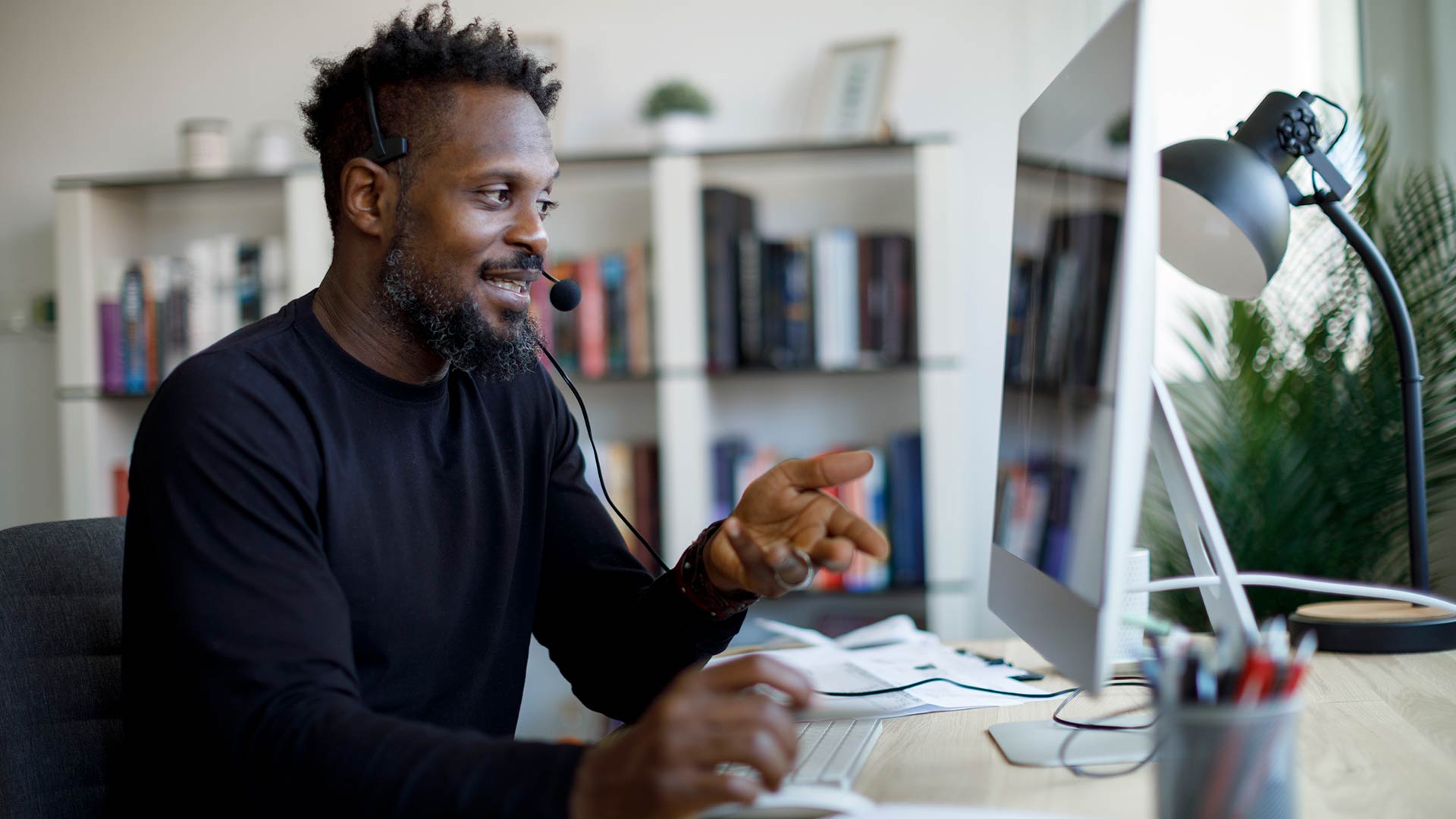 Man on desktop interacting with a web camera.