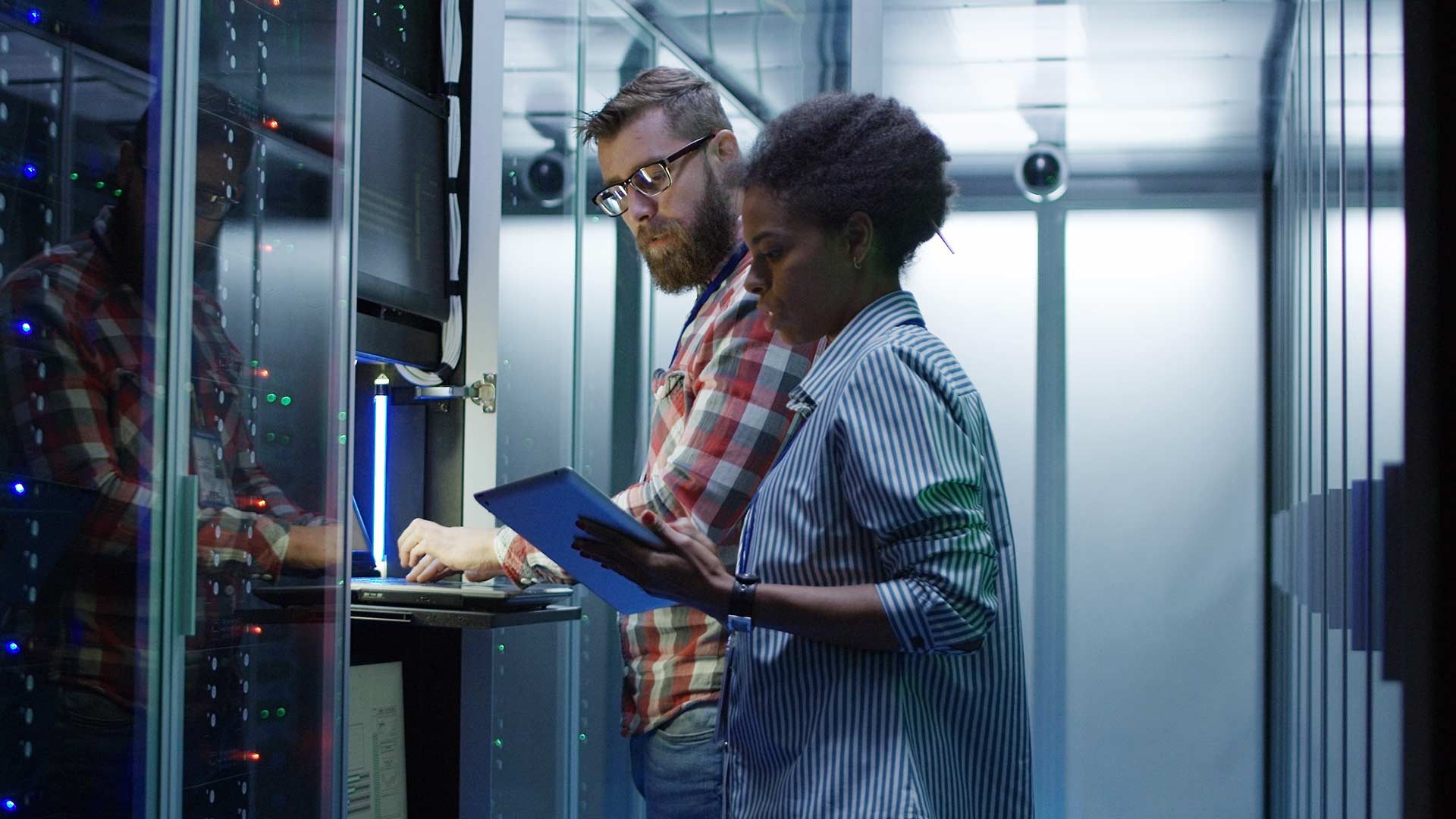 Two people working in a server room