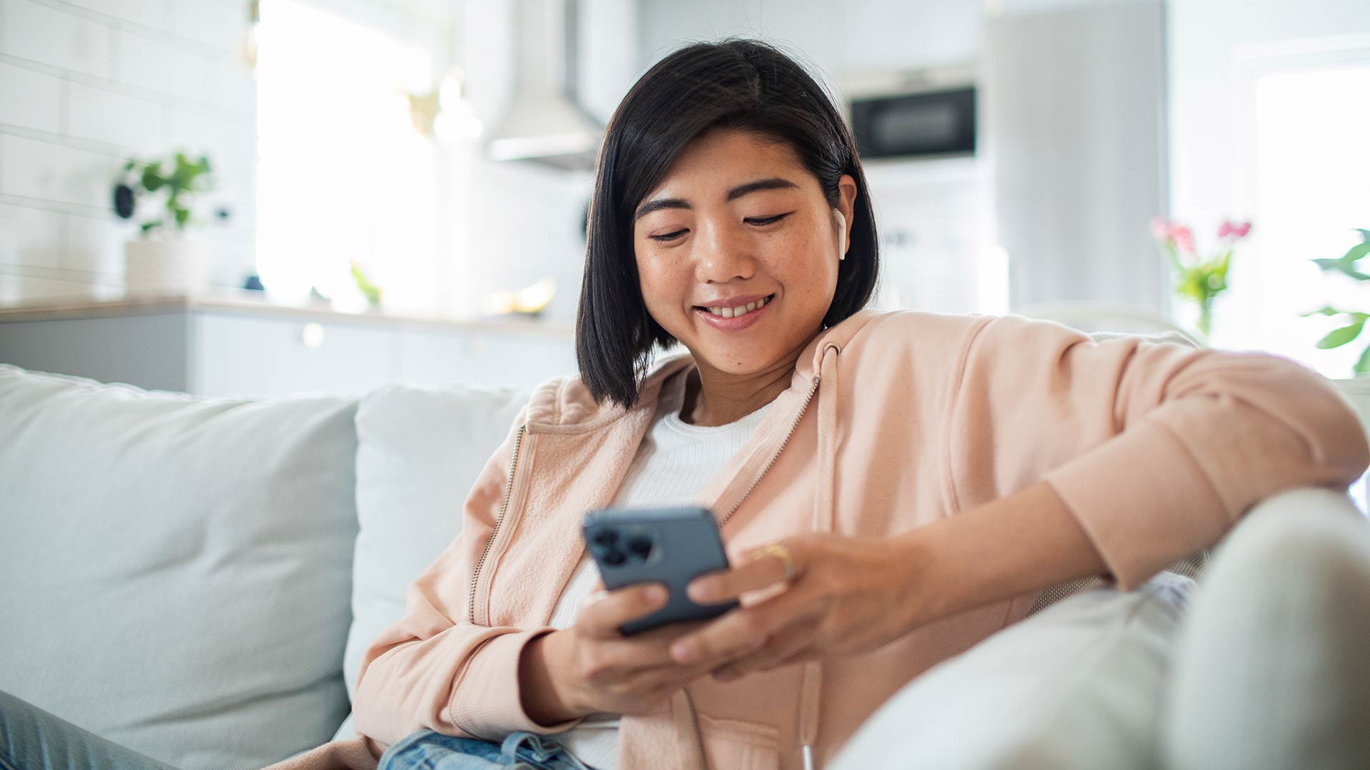 Woman on a couch looking at her cell phone